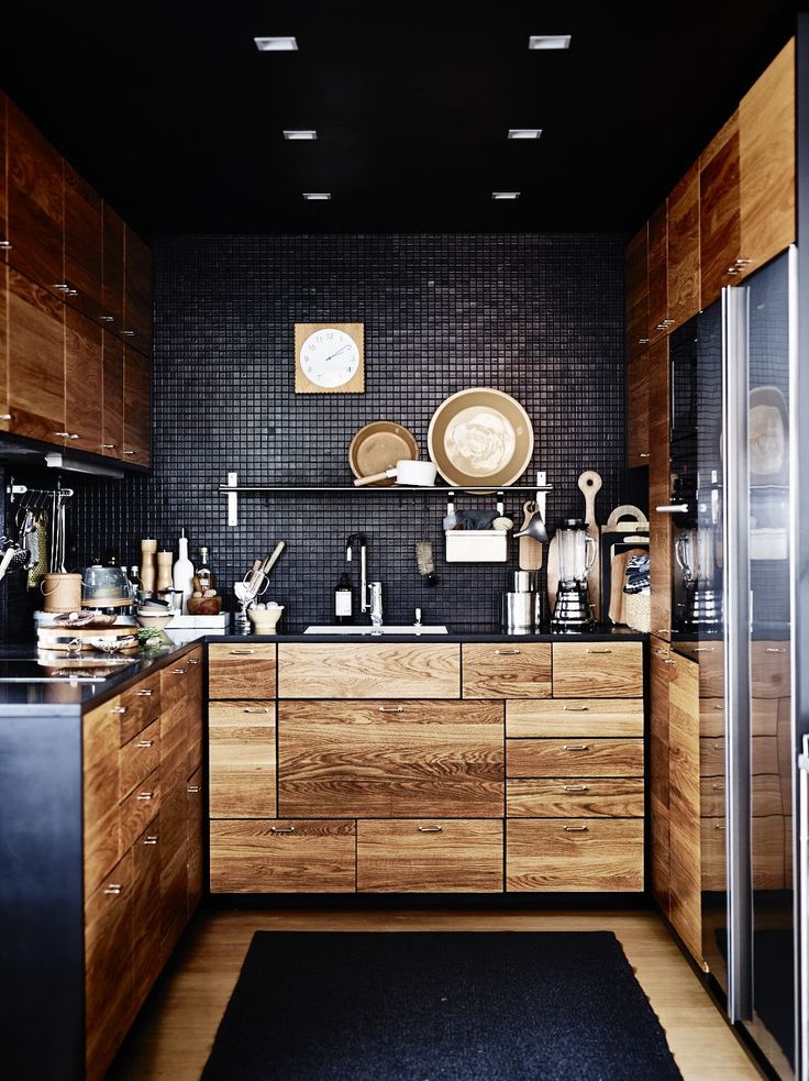 Уголок кухни с деревянными фасадами и черной мозаикой